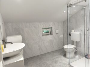 Prenovljena kopalnica brez ploščic z umivalnikom in kopalniškim pohištvom